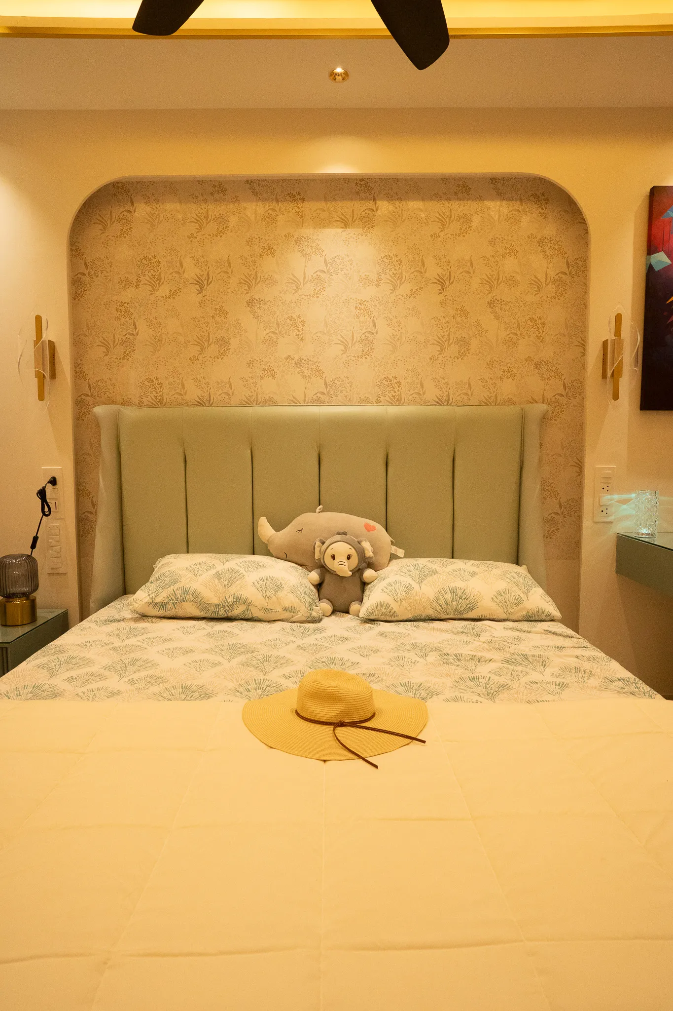 Bed with sage headboard in an arched backlit alcove — Divyarjuna